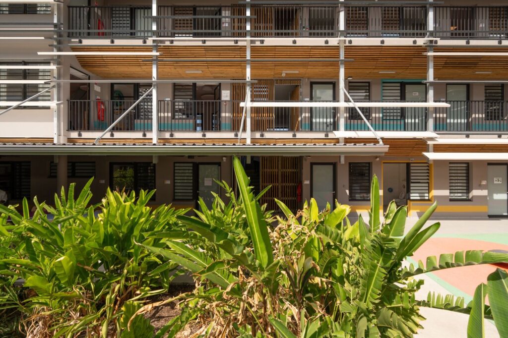 Façade à brise-soleil de l'IRSAM et végétation tropicale
